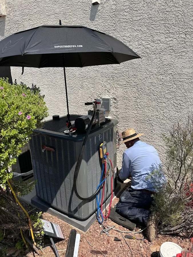 HVAC technician performing outdoor AC maintenance in Troy